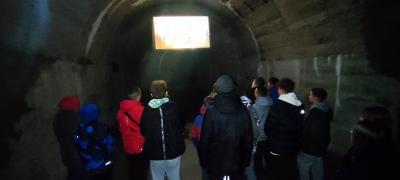 Uczniowie oglądają prezentację multimedialną w podziemiach Zamku w Książu