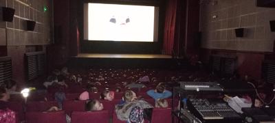 Oglądanie w skupieniu bajki w kinie przez przedszkolaki, Zdjęcie zrobione  w czasie seansu filmowego