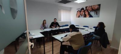 Uczestnicy zajęć w sali lekcyjnej w czasie zajęć językowych.