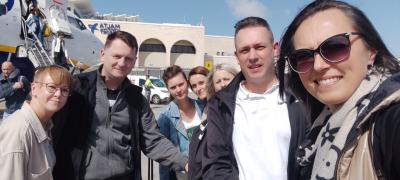 Grupa nauczycieli na płycie lotniska na Malcie.
