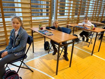 uczniowie czekają na konkurs siedząc w ławkach