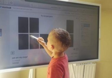 Na interaktywnym monitorze wyświetlają sięczarne prostokąty, które dotykiem odsłania uczeń
